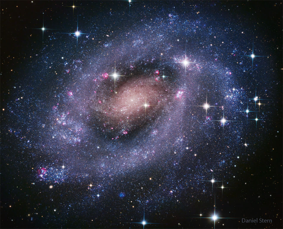 A classic spiral galaxy is shown with blue spiral
arms. The center is yellow-red. Many star clusters are 
easily visible. 
Please see the explanation for more detailed information.