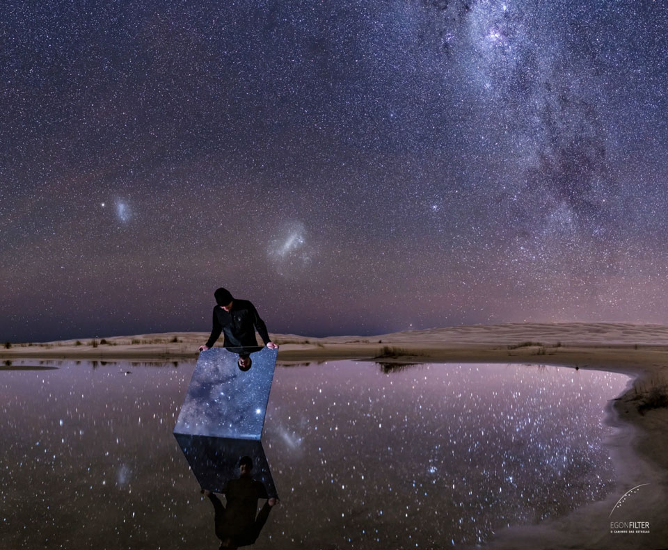 The picture shows a clear night sky from Brazil that is not only reflected from standing water but by a person holding a mirror. Please see the explanation for more detailed information.