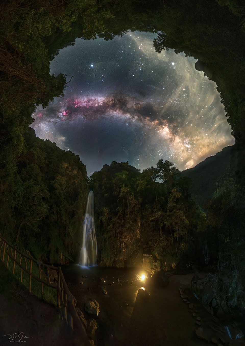 The picture shows a waterfall under a night sky 
dominated by the arch of our Milky Way Galaxy. 
Please see the explanation for more detailed information.