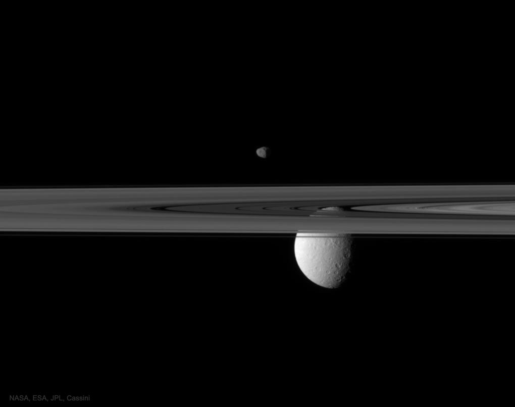 The featured image shows the Moons Rhea and Janus being the rings of Saturn as captured by the robotic  Cassini mission in 2010. Please see the explanation for more detailed information.