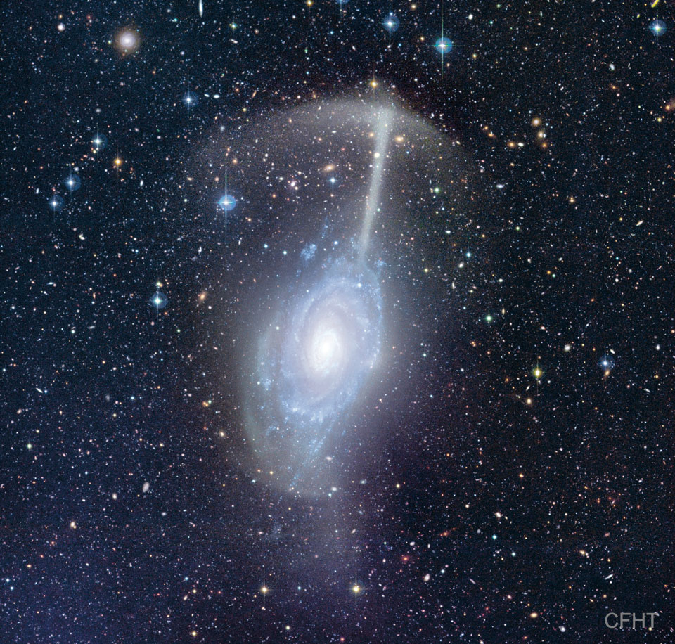 The featured image shows a galactic merger together called the Umbrella Galaxy because the remnants of one  galaxy have been left looking like an umbrella hovering  over the other galaxy. Please see the explanation for more detailed information.