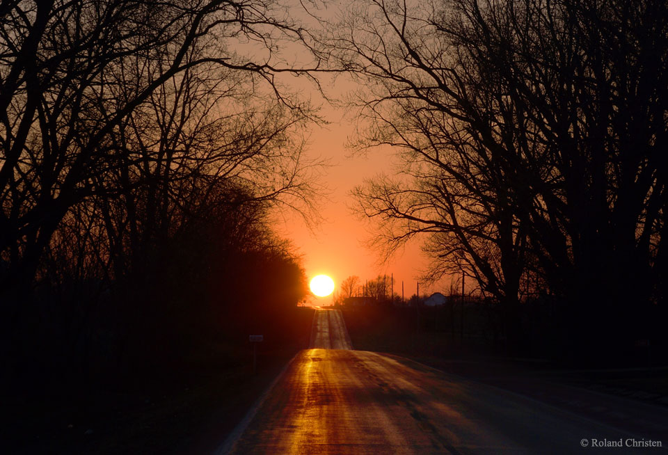 The featured image depicts a sunset down a country road
in Illinois. On an equinox, the Sun rises and sets directly
down east-west running roads like this. Many towns have them.
Please see the explanation for more detailed information.