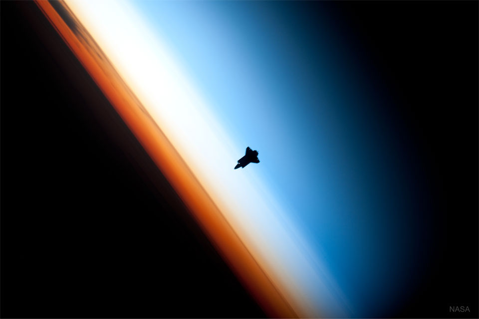 The featured image shows a the NASA space shuttle approaching the International Space Station with the Earth's atmosphere in the background.  Please see the explanation for more detailed information.