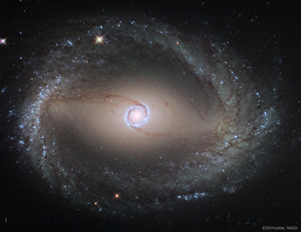 La imagen destacada muestra la galaxia espiral NGC 1512 tomada por el telescopio espacial Hubble.  La galaxia muestra dos anillos que rodean su centro.  Consulte la explicación para obtener información más detallada.