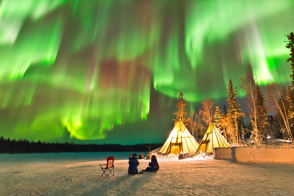 The featured image tipis below a night sky lit up  with multiple green auroras.  Please see the explanation for more detailed information.