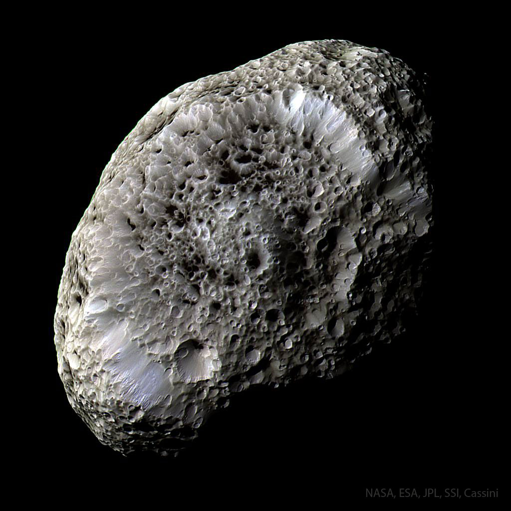 An oblong moon is shown that appears sponge like and 
features many odd craters. Close inspection shows that the 
bottoms of these craters are covered with a dark material.
Please see the explanation for more detailed information.