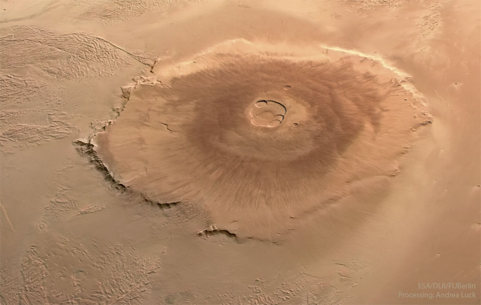 A large orange volcano is pictured on Mars from above.  Please see the explanation for more detailed information.