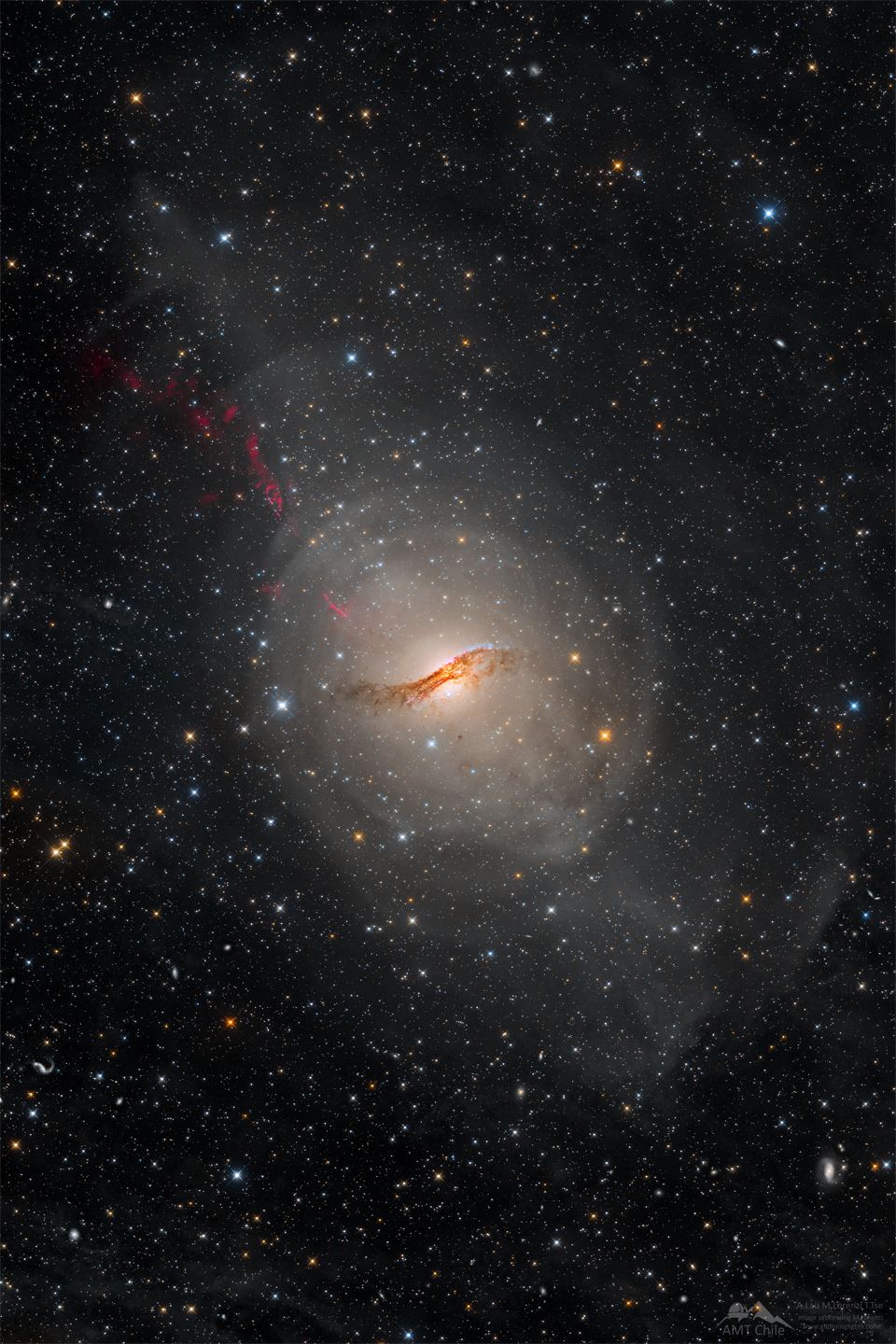 A long duration image of the unusual galaxy Centaurus A. The galaxy appears as a light oval with a complex dark dust lane running across its center. A starfield surrounds the galaxy. Please see the explanation for more detailed information.