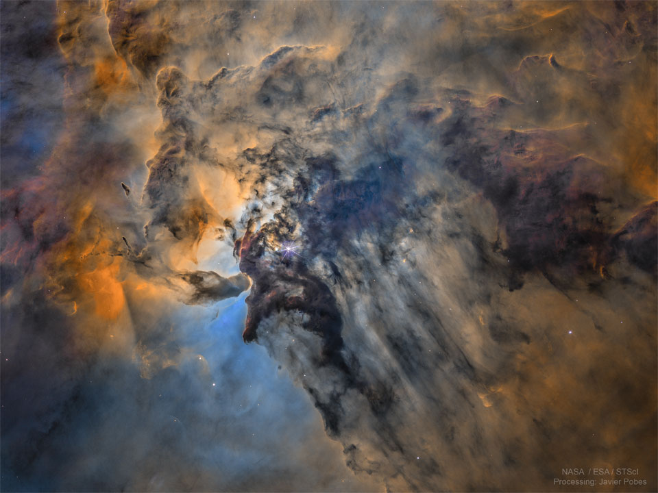 The center of the Lagoon Nebula is pictured in false colors.   Toward the center left, dark dust swirls around glowing gas and bright stars.  Please see the explanation for more detailed information.