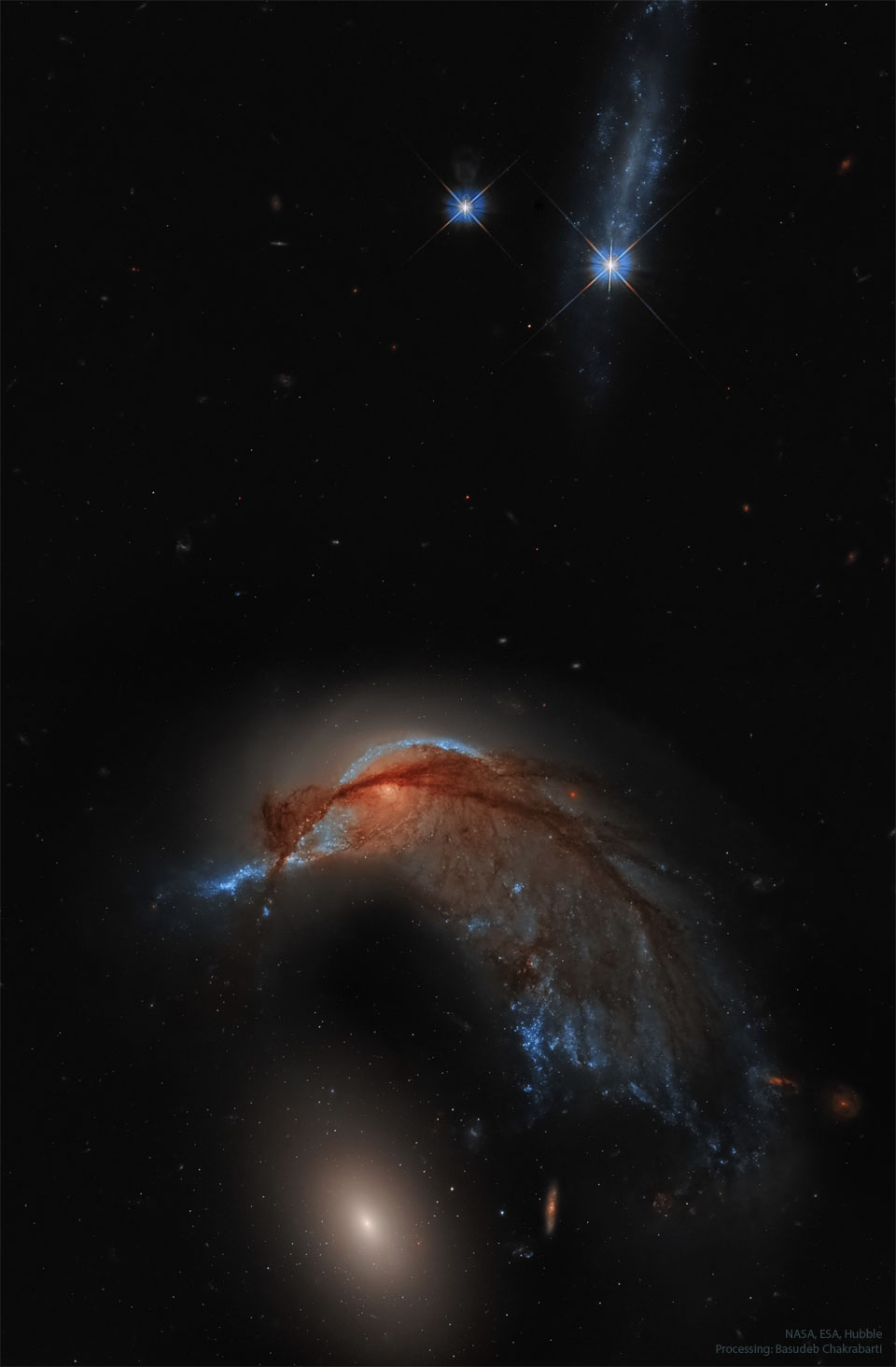 A starfield with two bright stars at the top of the frame
and two galaxies at the bottom. The upper galaxy is a spiral
galaxy and has an appearance reminiscent of a hummingbird. The lower
galaxy is a featureless elliptical galaxy.  
Please see the explanation for more detailed information.