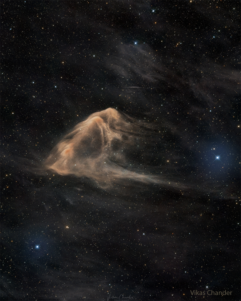 A light brown nebula is seen on a dark starfield. The 
outline of the nebula makes it appear like an eagle ray fish. 
Please see the explanation for more detailed information.