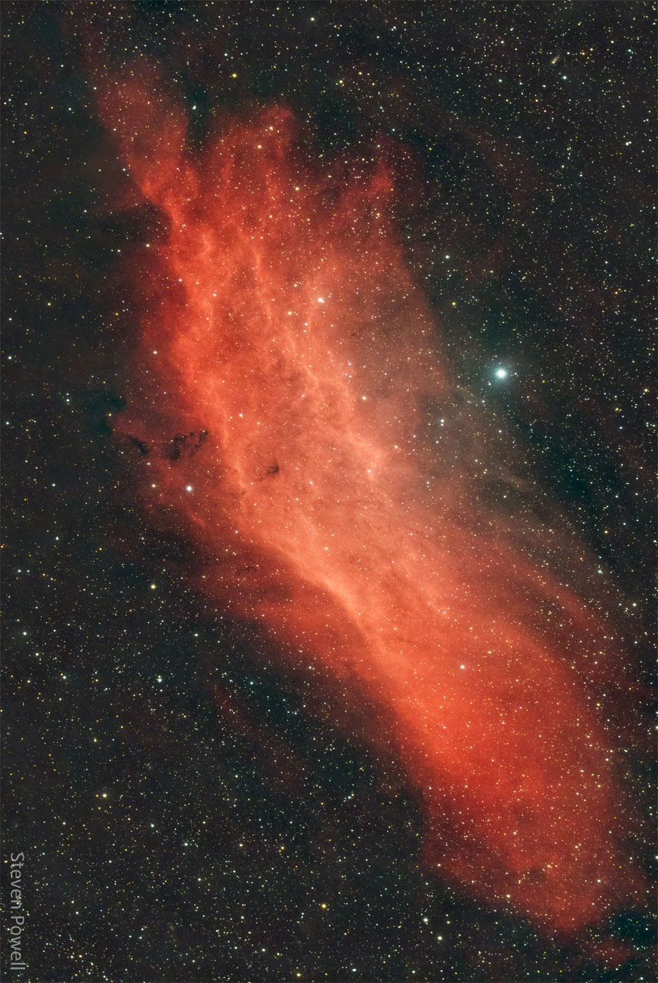 A red gaseous nebula is shown in front of a dark starfield.
The shape of the nebula resembles the US state of California.
Please see the explanation for more detailed information.