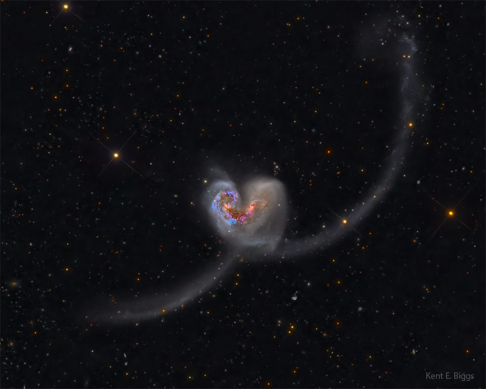 Two galaxies are seen colliding the image center. 
Together, they look like a classic heart icon but with
long tails. 
Please see the explanation for more detailed information.