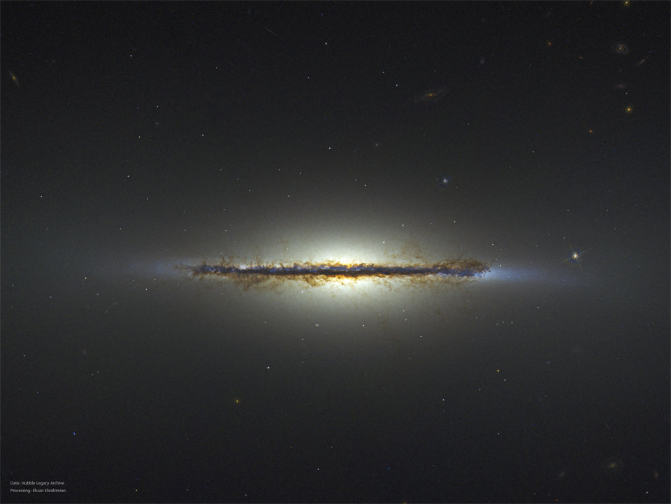 A starfield is shown with an unusual horizontal line segment running throug the middle. The segment is an edge-on galaxy and many brown dust filaments are visible. Please see the explanation for more detailed information.
