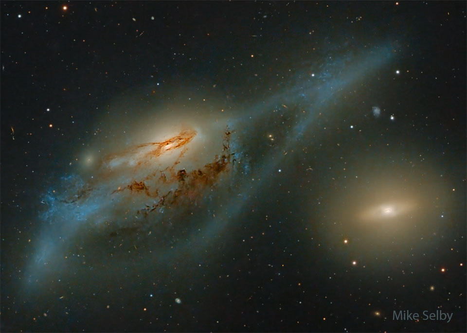 Two large galaxies are pictured. On the left is a
distorted spiral galaxy, while on the right is a relatively
featureless yellow disk galaxy. Together, these galaxies
may look, to some, like a pair of eyes.
Please see the explanation for more detailed information.
