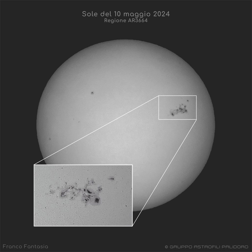 Im Bild ist die Sonne grau abgebildet. Rechts ist eine riesige Sonnenfleckengruppe. Diese ist in einem Einschub unten links vergrößert dargestellt.