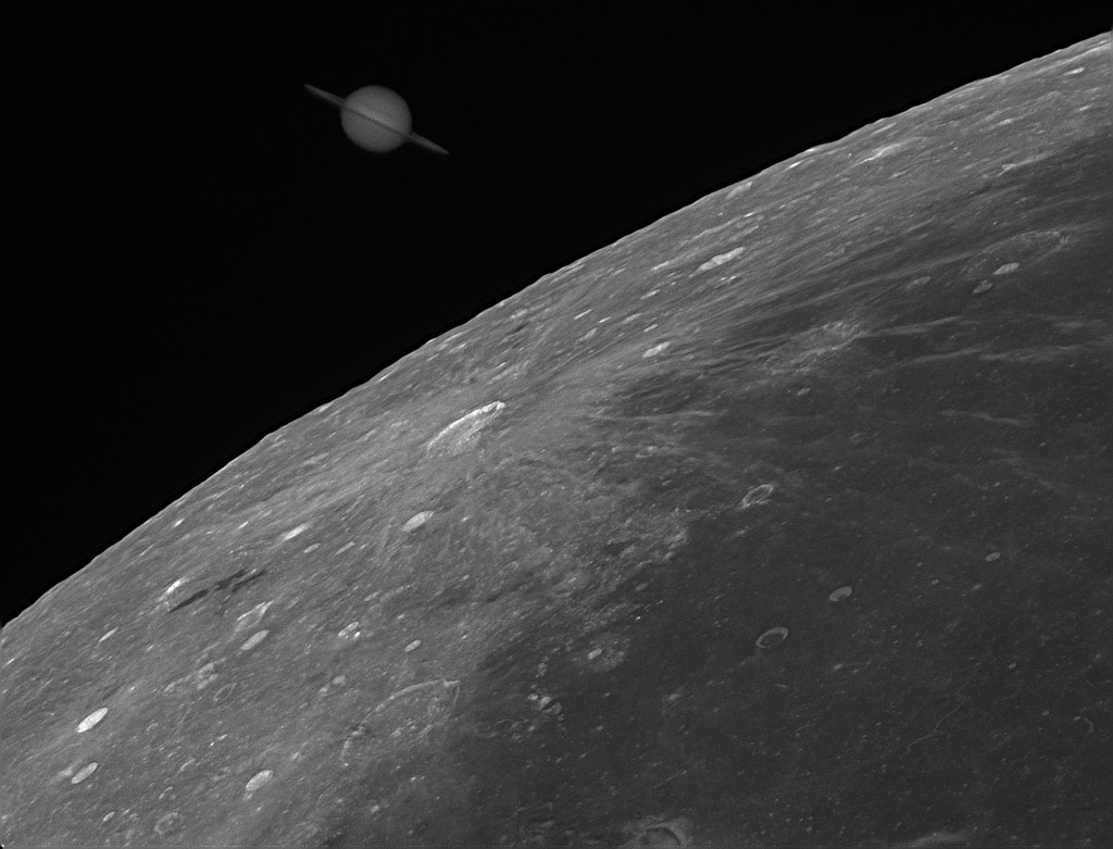 Links über dem Mondrand und einem kleinen Ausschnitt des Mondes mit vielen Kratern geht Saturn auf. Im Vergleich zum Mond ist er nur schwach beleuchtet.