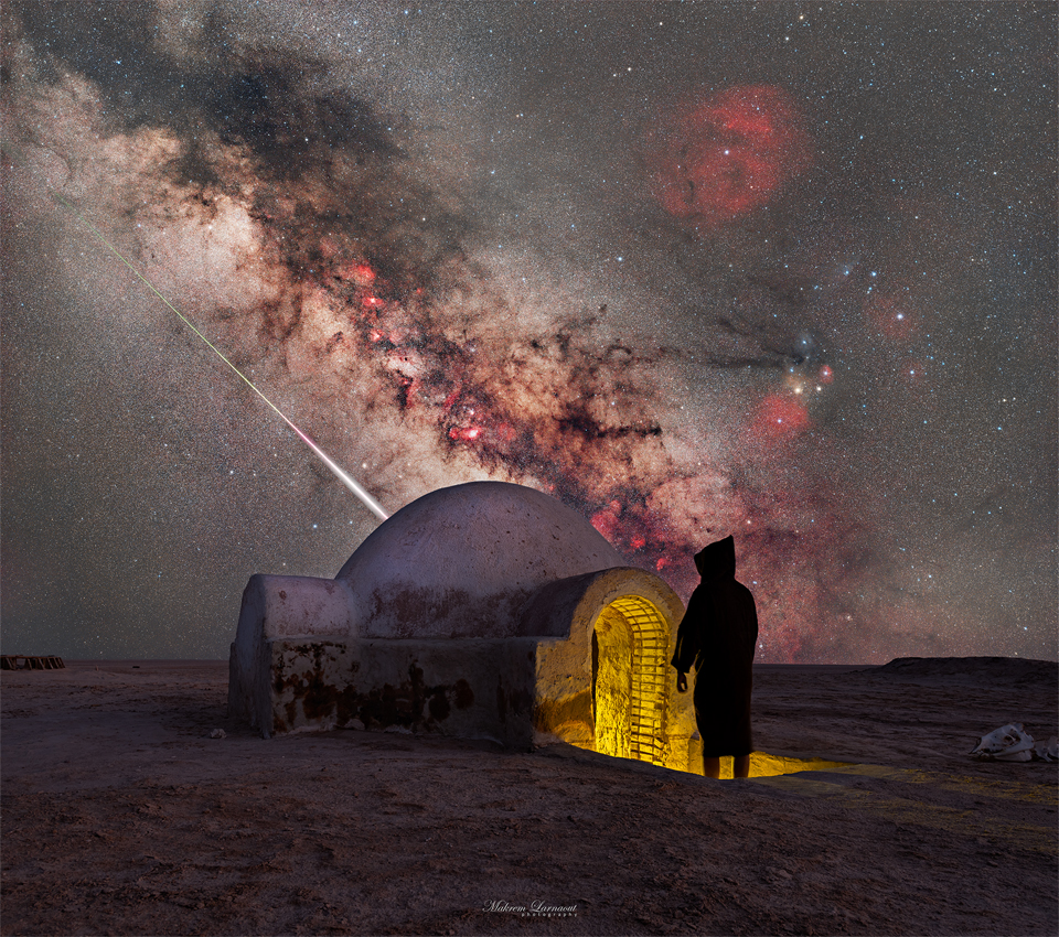 A starry sky is seen above a structure with an iconic  dome. A person in shadow stands at the entrance. Sloping down   in the sky is the central band of our Milky Way Galaxy. Just   below the Milky Way is the streak of a bright meteor.   Please see the explanation for more detailed information.