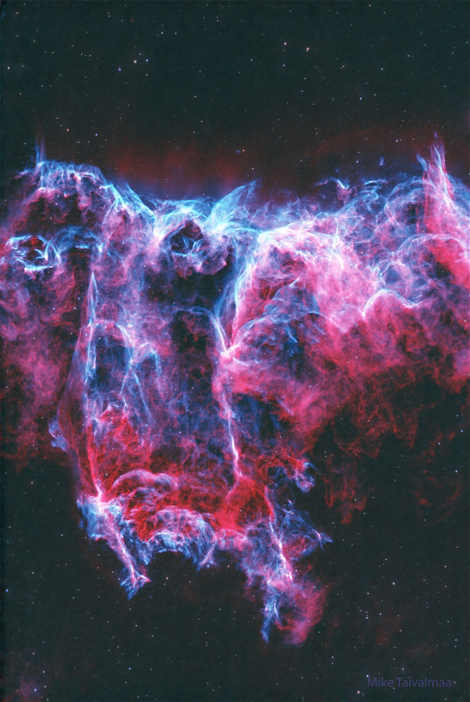 The featured image shows a starfield with a two-  colored nebula in the center. The nebula is colored   mostly red and blue.   Please see the explanation for more detailed information.