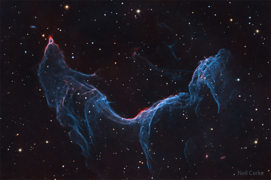 A starfield is shown with a long blue-glowing nebula  taking up much of the frame. The nebula appears, to some,  similar to a fish or a mermaid.   Please see the explanation for more detailed information.