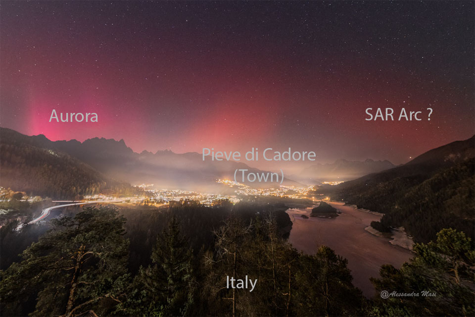 A star field appears above a town at night. The left part
of the sky shows a pinkish-red glow that is an aurora, while the
right part of the sky shows a smoother and darker glow that is
a SAR arc. 
Please see the explanation for more detailed information.