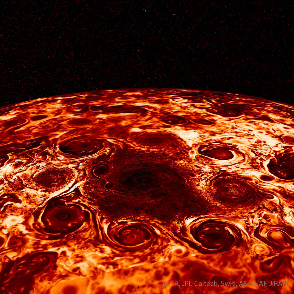 The image shows the north pole of Jupiter in red  (infrared) light. Many cyclonic swirls surround the pole.  Please see the explanation for more detailed information.