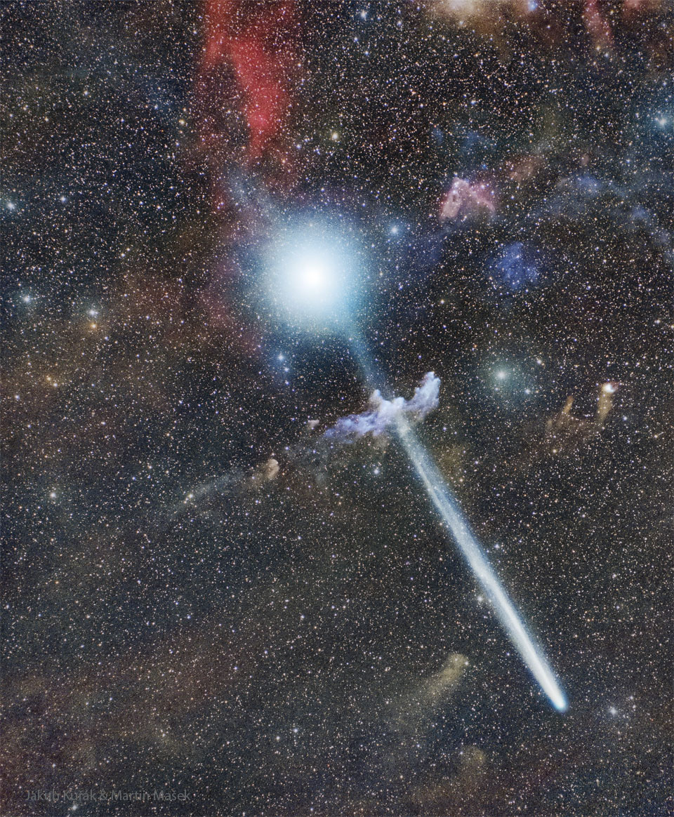 A starfield appears with three large objects. Near the top is a 
bright star. Near the middle is a small light blue nebula. And 
near the bottom is a comet with its long tail extending to the 
upper left and passing in front of both the star and the blue 
nebula. 
Please see the explanation for more detailed information.