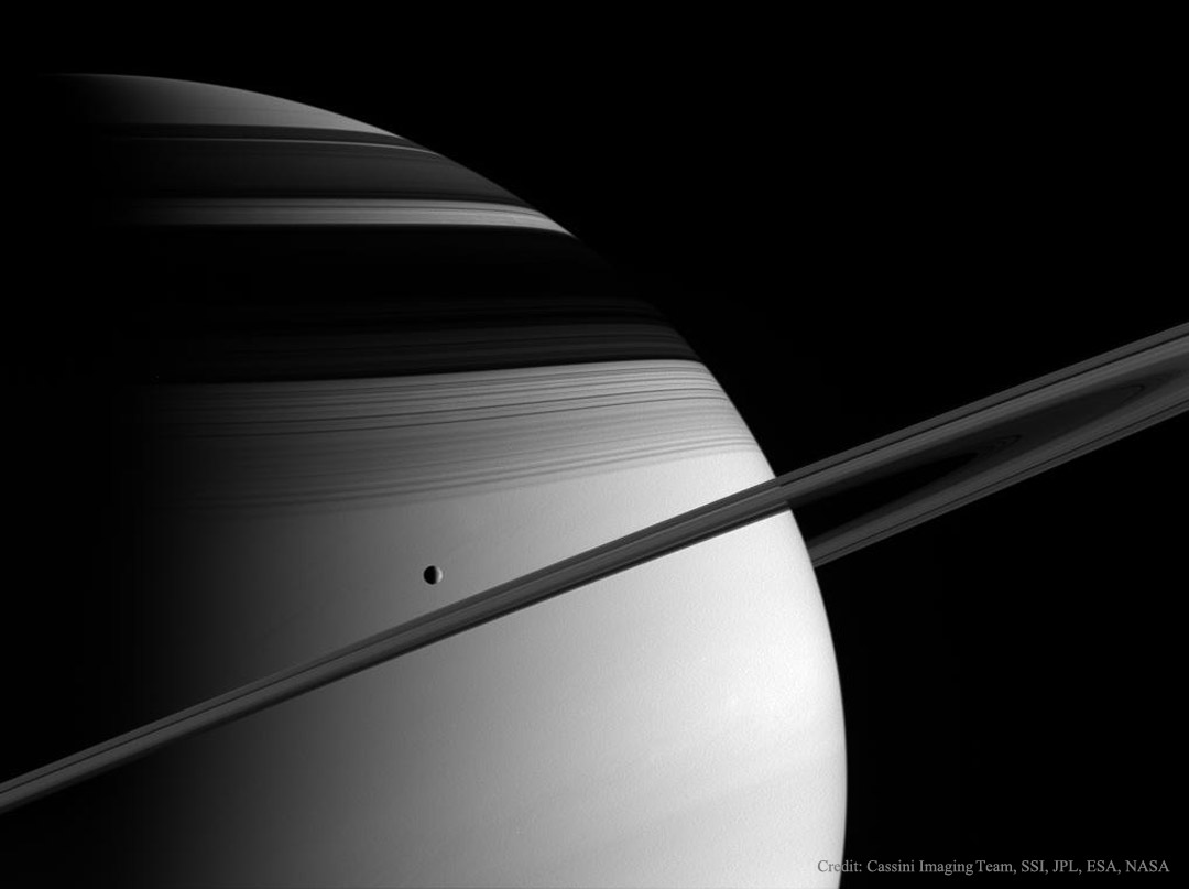 The featured image shows Saturn, its rings nearly edge-on,
shadows of its rings on the planet's face, and the ice-moon
Tethys. The image was taken by Cassini in 2005.
Please see the explanation for more detailed information.