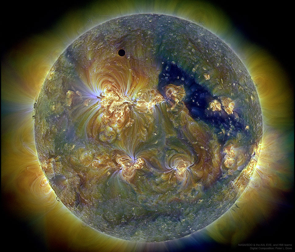 An image of the Sun in three bands of ultraviolet light
showing the transit circle of Venus, a deep coronal hole, and
Please see the explanation for more detailed information.