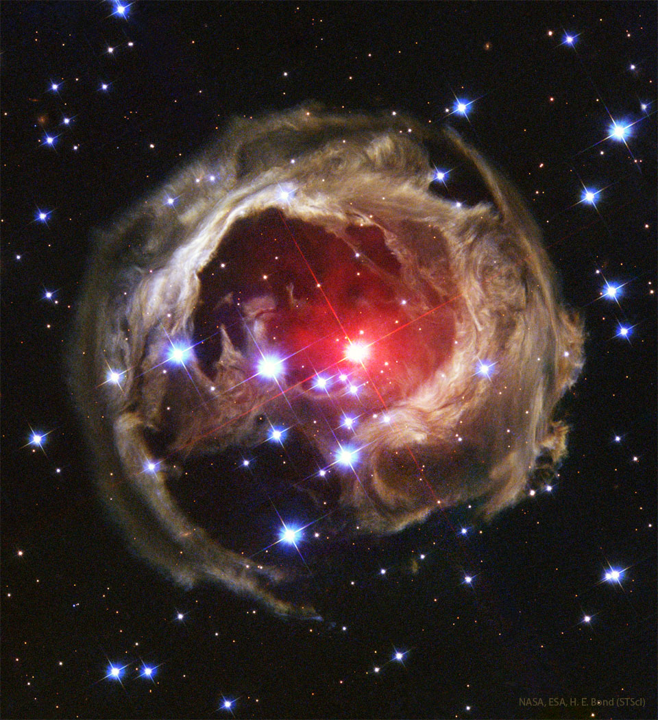 The featured image shows the unusual light
echo structure known as V838 Mon. The illuminated dust
is patchy and surrounds a bright red-colored star.
Please see the explanation for more detailed information.