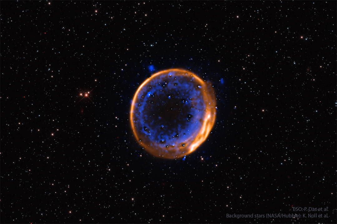 A nearly circular nebula with two rings is shown. 
The outer ring appears orange while while the inner 
rings is more complex and appears blue. 
Please see the explanation for more detailed information.