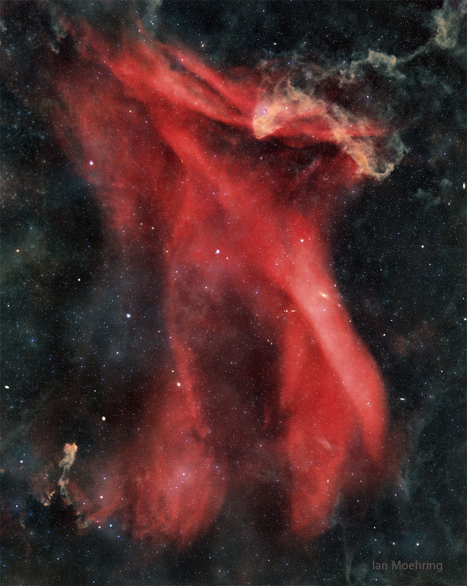 A starfield surrounds a large red nebula.
The nebula has many flowing waves and folds.
Please see the explanation for more detailed information.
