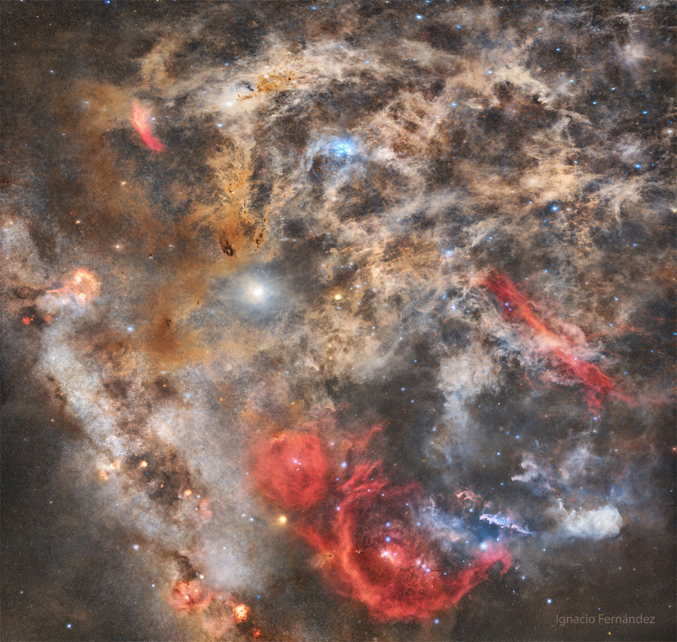 The featured image shows a dusty starfield with intricate
dust filaments all over. Red, blue, and brown nebulas will the 
field. 
Please see the explanation for more detailed information.